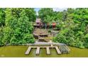 Back of a house with a multi-tiered deck leading to a private boat dock on a lush waterfront property at 22 Point Ln, Arcadia, IN 46030