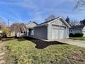 Inviting single-Gathering home features a two-car garage, gray siding and a well-maintained lawn at 2620 E 56Th St, Indianapolis, IN 46220