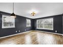 Bright living room featuring three large windows and decorative lighting at 2702 N Talbott St, Indianapolis, IN 46205
