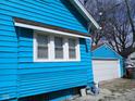 Exterior view showing the light blue siding and white trim, highlighting the garage at 3035 Graceland Ave, Indianapolis, IN 46208