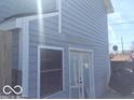 Home exterior featuring light blue siding, white trim, and storm door at 3036 Chase St, Indianapolis, IN 46217