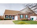 Charming brick house with a two-car garage, manicured lawn, and inviting front porch with green shutters at 5180 Dunewood Way # 57, Avon, IN 46123