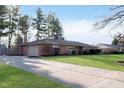 Brick ranch home with long driveway, attached garage and manicured front lawn at 6407 Brokenhurst Rd, Indianapolis, IN 46220