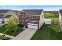 Desirable home featuring a well-manicured lawn, brick facade, two-car garage, and inviting curb appeal at 6862 School Branch Dr, Brownsburg, IN 46112