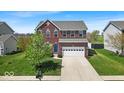Charming two-story red brick home with a well-manicured lawn and attached two-car garage at 6862 School Branch Dr, Brownsburg, IN 46112