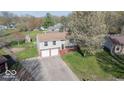 Aerial view of a two-story home with an attached garage and tree-lined lot at 7733 Opelika Ct, Indianapolis, IN 46217