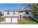 Two-story home featuring an attached two-car garage and brick-accented facade at 7733 Opelika Ct, Indianapolis, IN 46217