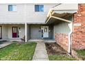Two-story townhouse featuring classic siding, brick accents, and walkway to entry door at 11931 E Welland St, Indianapolis, IN 46229