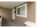 A cozy covered porch features neutral siding, a white front door, and a space for welcoming visitors at 1231 S Pershing Ave, Indianapolis, IN 46221