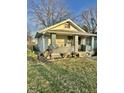 Street view of home featuring a covered front porch with two planters and green lawn at 1409 N Denny St, Indianapolis, IN 46201