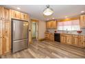 Modern kitchen with stainless steel appliances, wooden cabinets, and laminate flooring at 241 S Walnut St, Jamestown, IN 46147