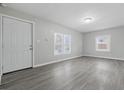 Inviting living room featuring neutral paint, gray flooring, and ample natural light through multiple windows at 3710 Orchard Ave, Indianapolis, IN 46218