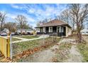 Classic bungalow-style home featuring a fenced yard, mature trees, and ample parking in a residential neighborhood at 3940 N Drexel Ave, Indianapolis, IN 46226