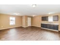 Large bright, open living room with hardwood floors and view of cabinets and sink at 5010 Elliott Ave, Indianapolis, IN 46201