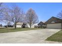 Charming brick home featuring an attached two-car garage and a well-manicured lawn at 5233 Birmingham Dr, Indianapolis, IN 46235