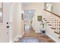 Bright foyer showcasing hardwood floors, a staircase, and views into the living room at 649 W Banta Rd, Indianapolis, IN 46217