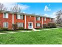 Attractive townhome exterior featuring a brick facade, blue front door, and lush lawn at 6515 Park Central Way # B, Indianapolis, IN 46260