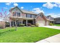 Charming two-story home with a well-manicured lawn and mature trees at 7233 Capel Dr, Indianapolis, IN 46259