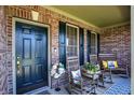 Inviting front porch features rocking chairs, floral arrangements and brick accents at 7233 Capel Dr, Indianapolis, IN 46259