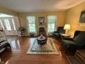 Open living room with beautiful hardwood floors, area rug, and natural light at 7341 Campfire Run, Indianapolis, IN 46236