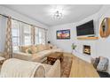 Cozy living room featuring a brick fireplace, large sectional sofa, and light-filled windows at 935 N Tacoma Ave, Indianapolis, IN 46201