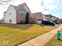 A well-maintained two story house with a brick facade and green lawn at 1407 Aggie Ln, Indianapolis, IN 46260