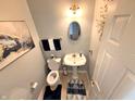 Stylish powder room with modern fixtures, decorative mirror, and attractive artwork at 1407 Aggie Ln, Indianapolis, IN 46260