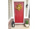 Inviting red front door adorned with a decorative wreath and stylish accents at 14241 Antiquity Dr, Carmel, IN 46033