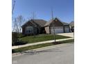 Beautifully landscaped single-story brick home with lush green lawn and mature trees at 15085 Thoroughbred Dr, Fishers, IN 46040