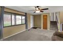 Inviting living room features plush carpet, neutral paint, bright windows, and staircase access for comfortable living at 1585 S 600 W, New Palestine, IN 46163