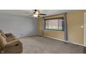 Comfortable living room features neutral paint, plush carpet, large windows, and a cozy sofa for relaxing at 1585 S 600 W, New Palestine, IN 46163