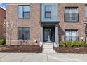 Close up of an inviting townhome entrance with a well-manicured garden, stone steps, and a stylish door at 1842 Central Ave, Indianapolis, IN 46202