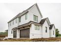 View of the side of this newly constructed home featuring white painted brick and vertical siding and a two-car garage at 19909 Windsor Park Blvd, Westfield, IN 46069