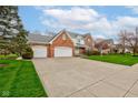 Classic brick home with an attached three-car garage and a long driveway, all on a well-kept lawn at 222 Wellington Pkwy, Noblesville, IN 46060