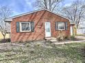 Cozy brick home with green shutters and budding flowers in the front yard, under a clear sky at 2253 Chandler Ln, Columbus, IN 47203