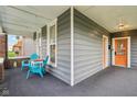Inviting porch featuring bright blue Adirondack chairs and a wooden table at 234 S State Ave, Indianapolis, IN 46201