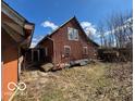 Two-story brick home with a gable roof and overgrown vegetation surrounding the property at 326 N Grant St, Brownsburg, IN 46112