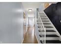 Hallway with wood floor and white staircase at 333 E Waterbury Rd, Indianapolis, IN 46227
