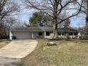 Inviting home exterior with concrete driveway, attached garage, and mature shade trees at 3516 Circle Blvd, Indianapolis, IN 46220