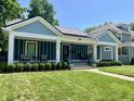 Attractive one-story home with metal roof, covered front porch, and lush green lawn at 3535 Birchwood Ave, Indianapolis, IN 46205