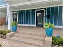 Inviting front porch with plants, sleek door, and well-manicured landscaping at 3535 Birchwood Ave, Indianapolis, IN 46205