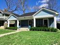 Charming curb appeal with a blue exterior, black roof, landscaped lawn, and inviting front porch at 3535 Birchwood Ave, Indianapolis, IN 46205