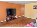 Spacious living area featuring hardwood floors, a modern television, and vibrant, contrasting wall colors at 3540 N Norfolk St, Indianapolis, IN 46224