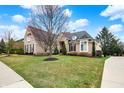 Beautiful brick home with manicured lawn, mature trees, and a charming entrance walkway at 3629 Pete Dye Blvd, Carmel, IN 46033