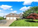 A beautiful two-story brick home with a four car garage, lush lawn and blue sky at 3862 Penzance Pl, Carmel, IN 46032