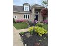 Close up of a home's front yard with lush flower beds and manicured lawn at 3862 Penzance Pl, Carmel, IN 46032