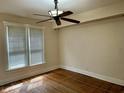 Bedroom featuring hardwood floors, a ceiling fan, and a large window with blinds at 418 N Drexel Ave, Indianapolis, IN 46201