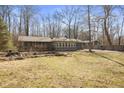 A charming single story home features a sunroom and a blue attached garage surrounded by trees at 4631 Berkshire Ln, Indianapolis, IN 46226