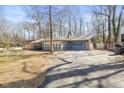 A charming single story home features a sunroom and a blue attached garage with a large driveway at 4631 Berkshire Ln, Indianapolis, IN 46226