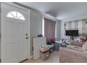 Bright living area with a white door, neutral walls, and a comfortable sofa at 5110 Chelsea Rd, Indianapolis, IN 46241